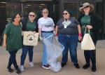 A group of people standing outside with trash bags